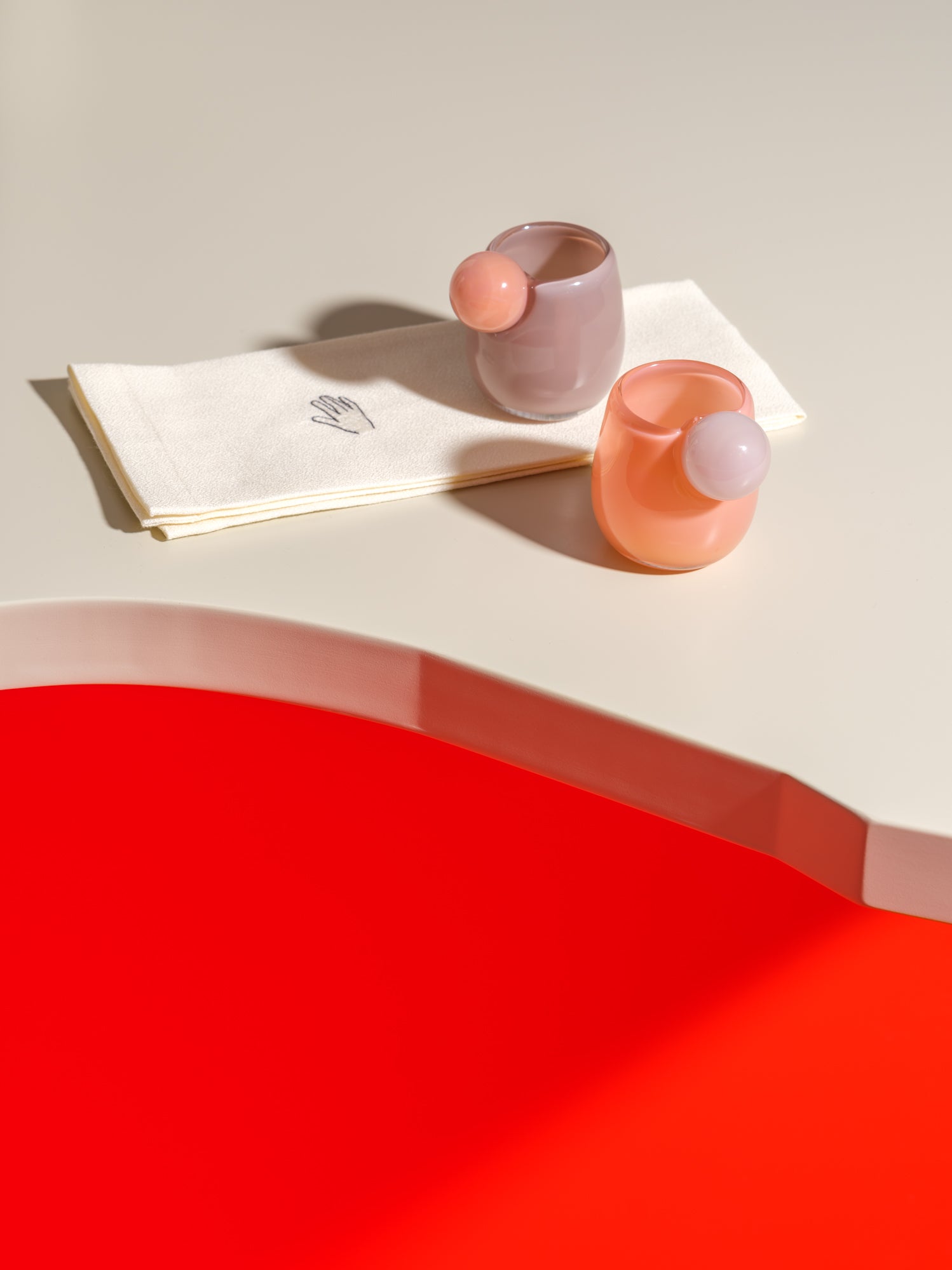 two small cups with a ball on the side in purple, pink and white